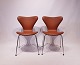 A pair of Seven chairs, model 3107, in cognac colored savanne leather, designed by Arne Jacobsen and Fritz Hansen.5000m2 showroom.